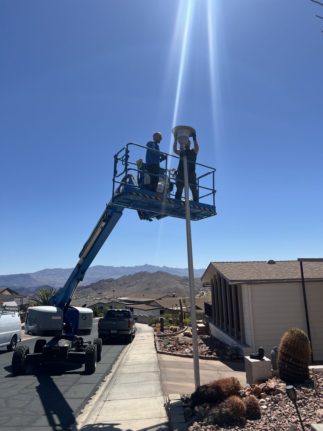 Tri Electric crew servicing an area light pole fixture from a boom lift