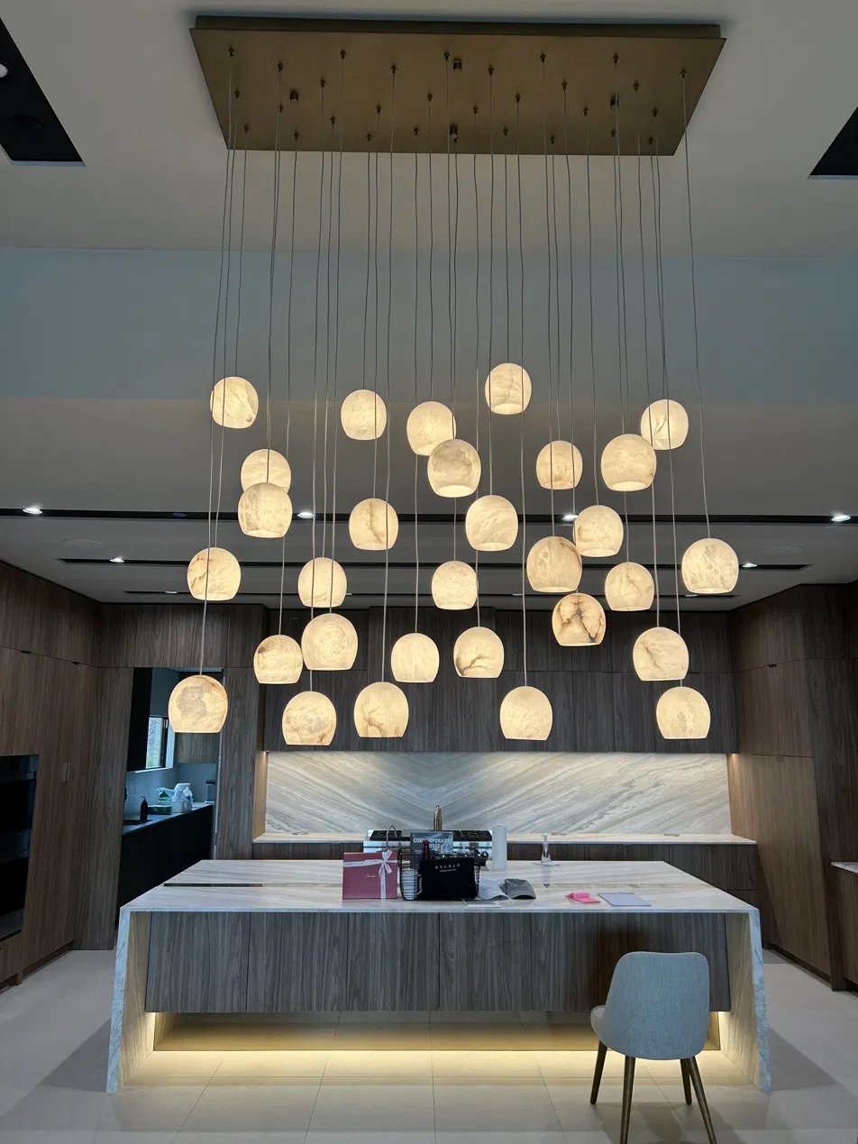 Multi-pendant alabaster chandelier installed over a kitchen island in a custom home