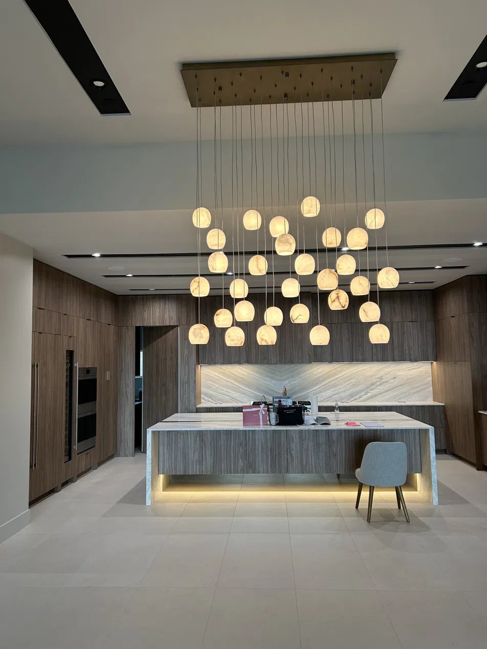 Finished kitchen with pendant chandelier, under-cabinet lighting, and island toe-kick lighting